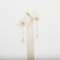 Dangle pearl earrings on a white background