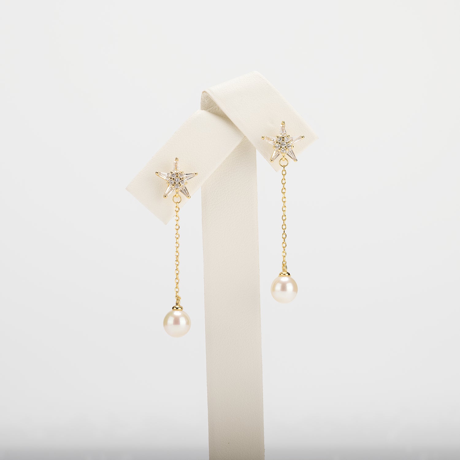 Dangle pearl earrings on a white background