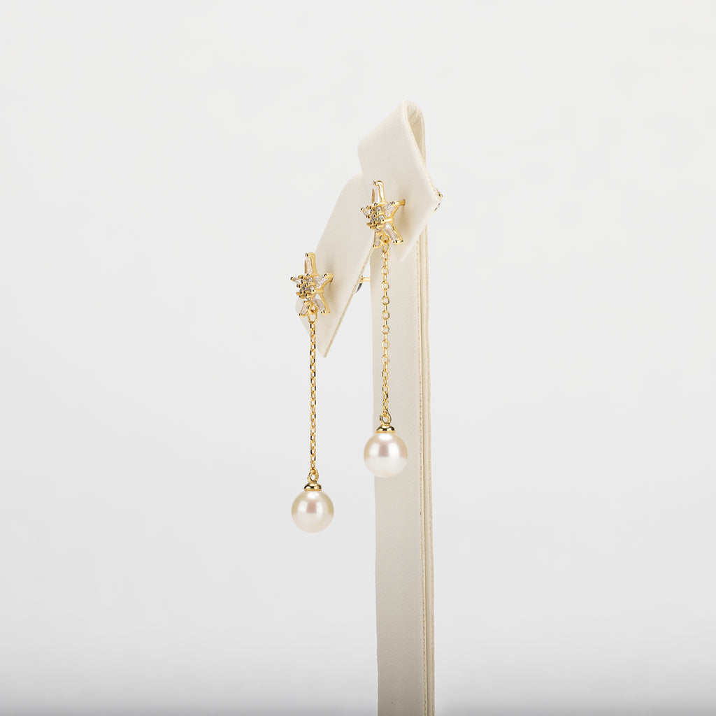 Dangle pearl earrings on a white background