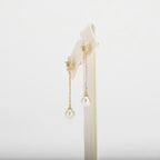 Dangle pearl earrings on a white background