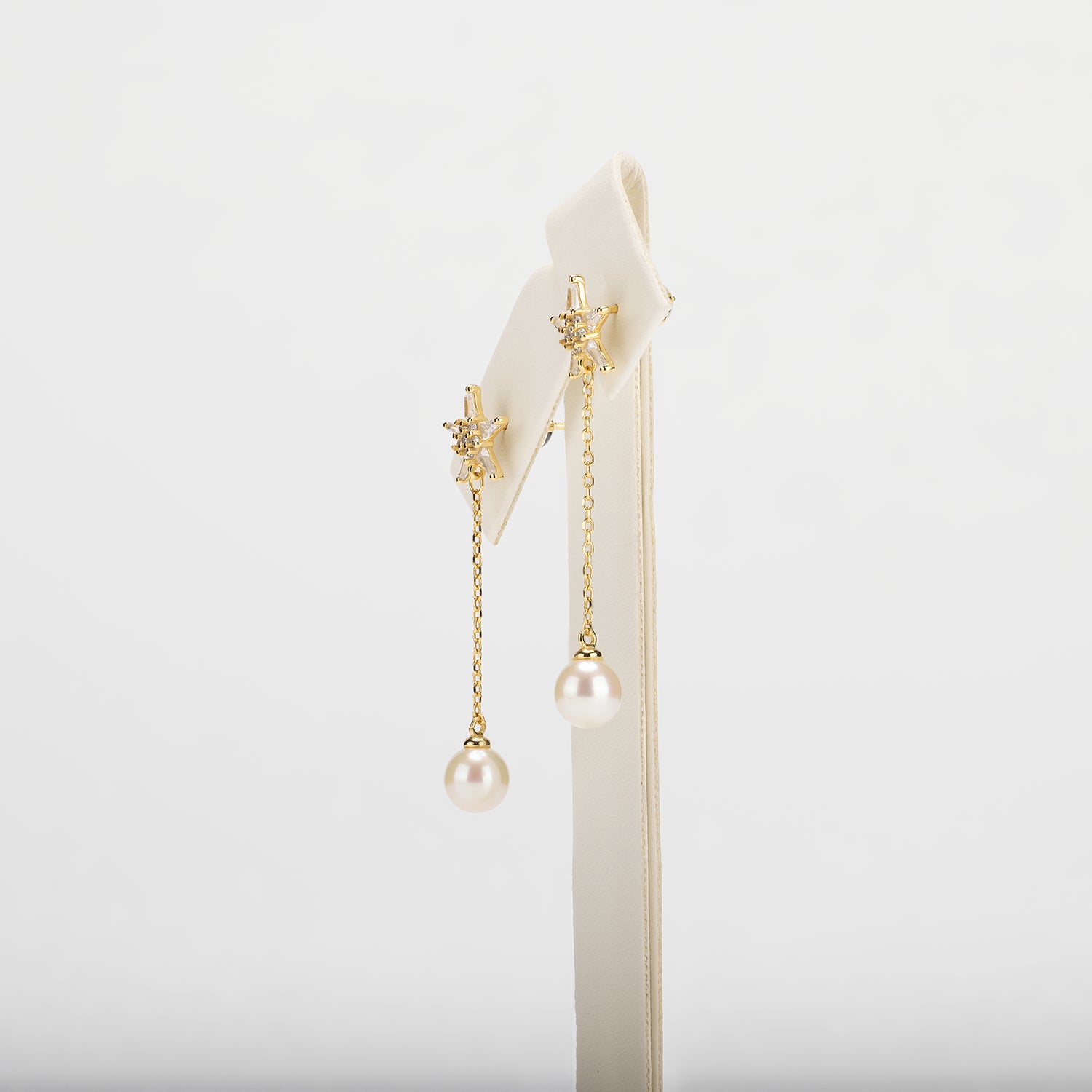 Dangle pearl earrings on a white background