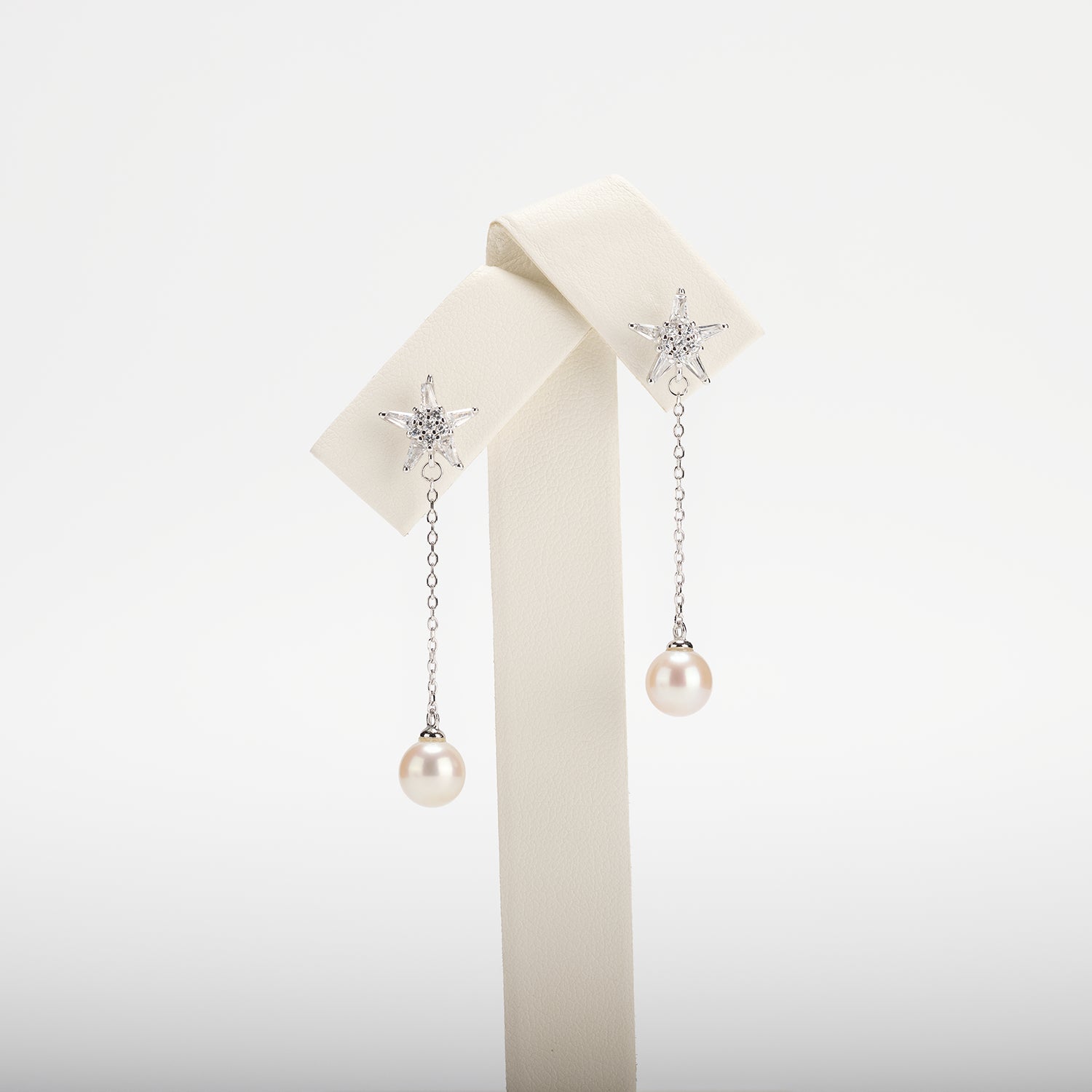 Dangle pearl earrings on a white background