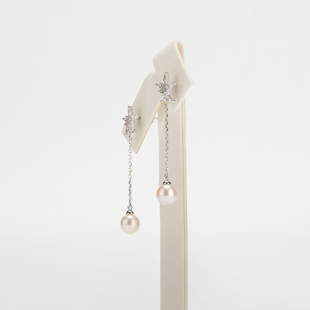 Dangle pearl earrings on a white background