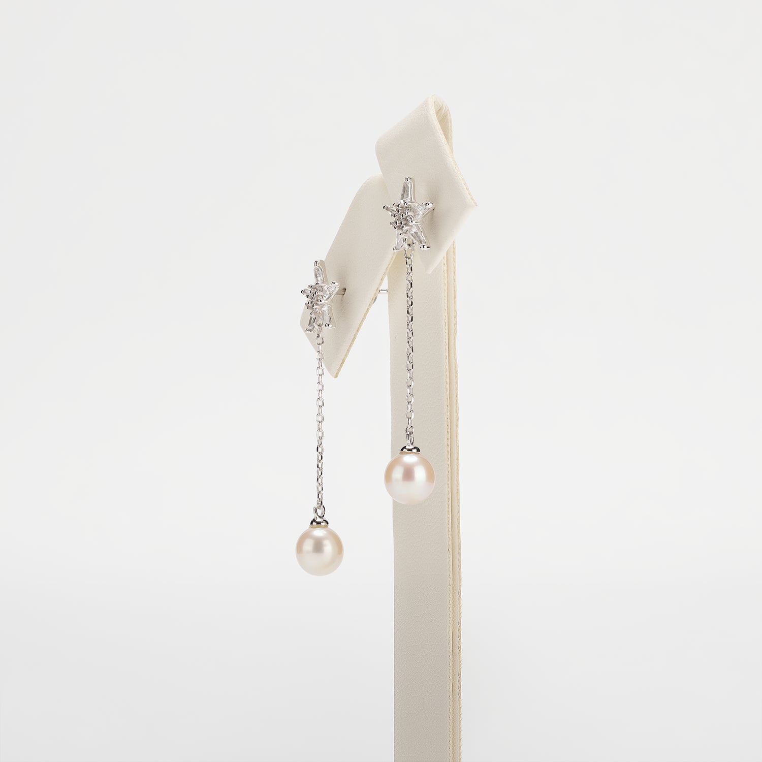 Dangle pearl earrings on a white background