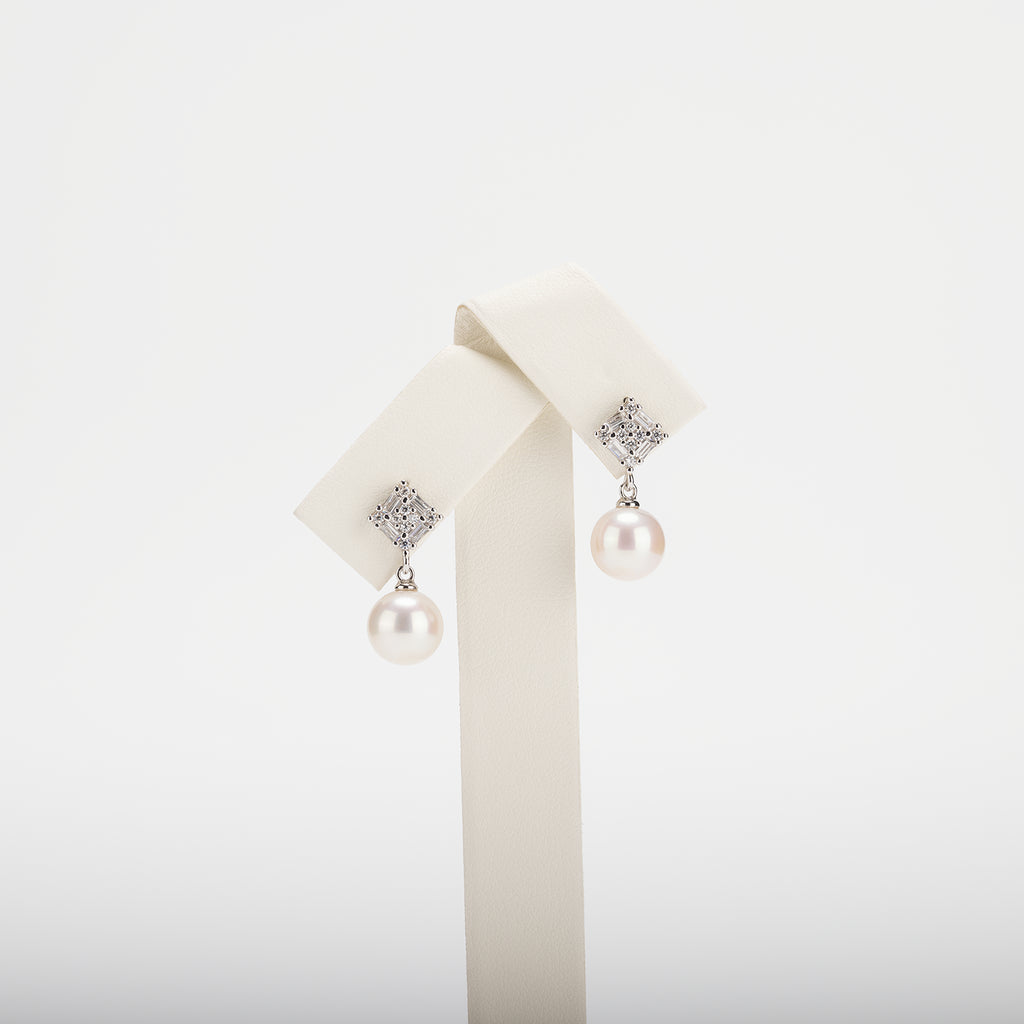 Pearl earrings with cubic zirconia on a  white background