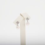Pearl earrings with cubic zirconia on a  white background