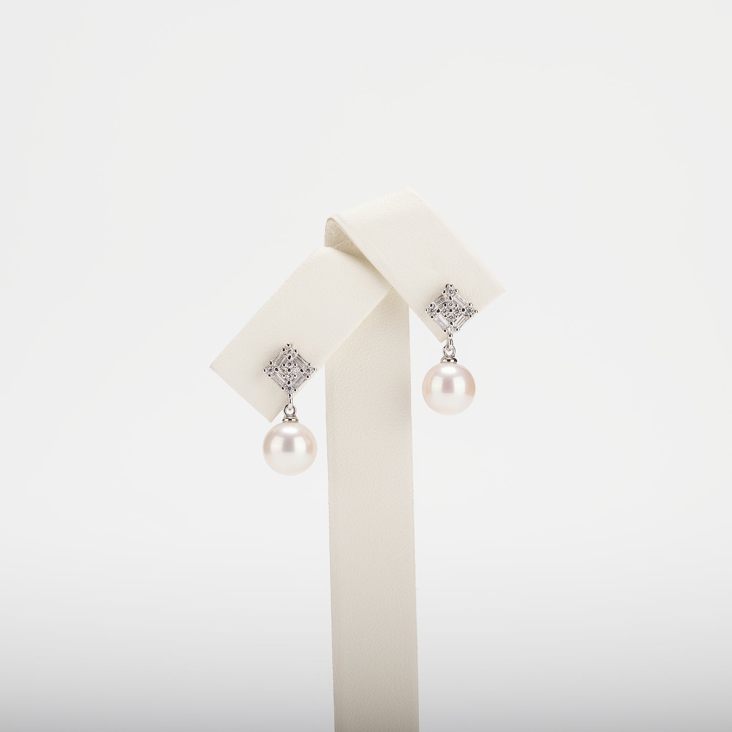 Pearl earrings with cubic zirconia on a  white background