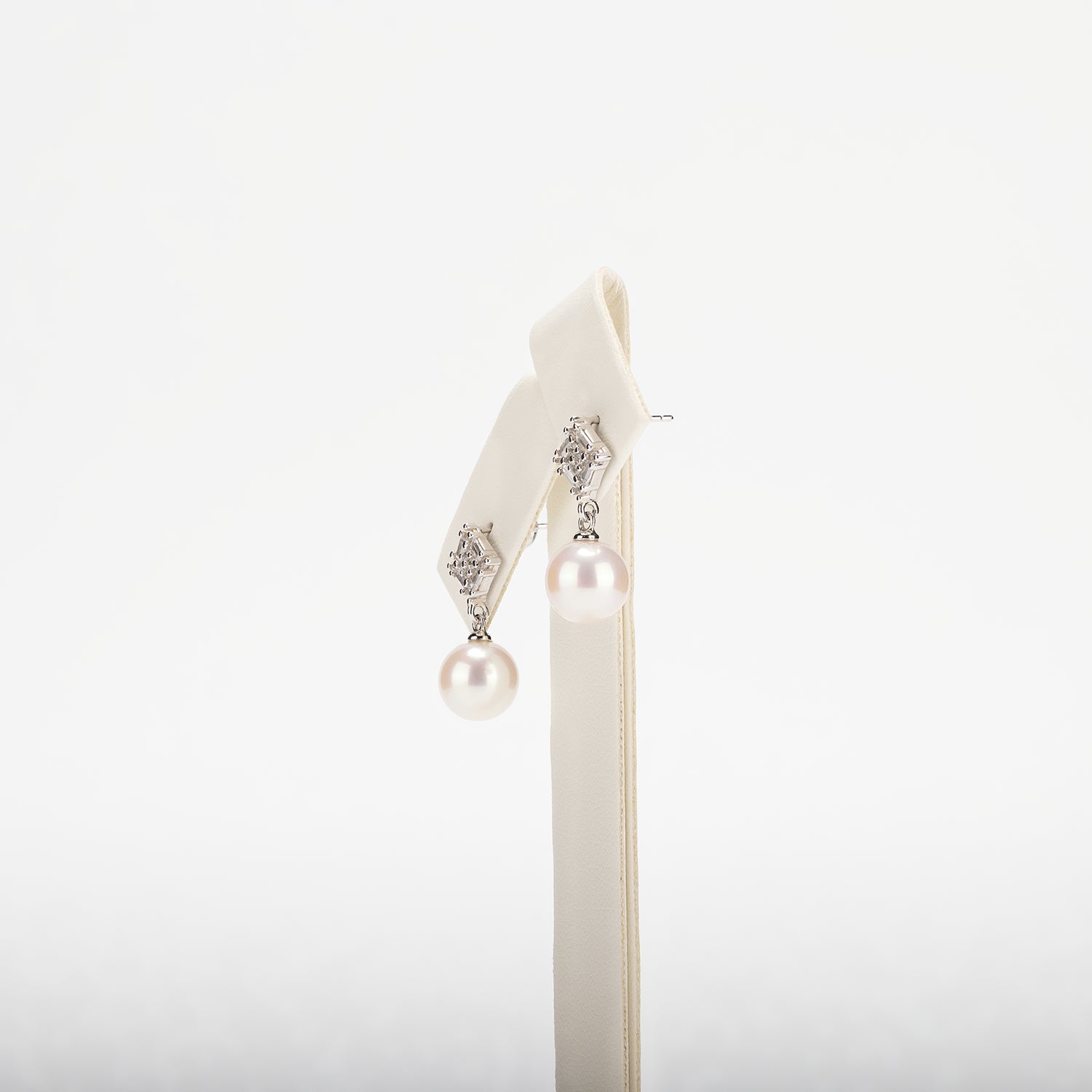 Pearl earring with decorative elements on a white background