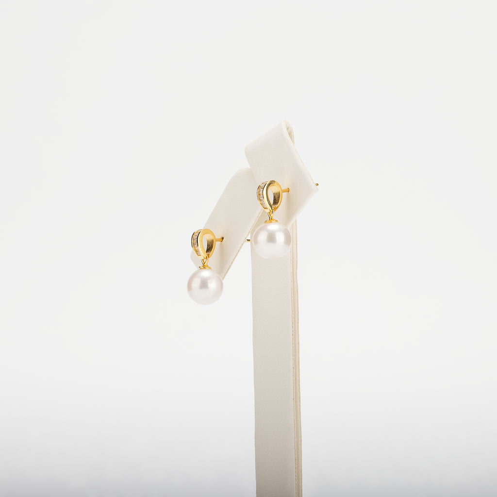 Pearl earring with gold clasps on a white background