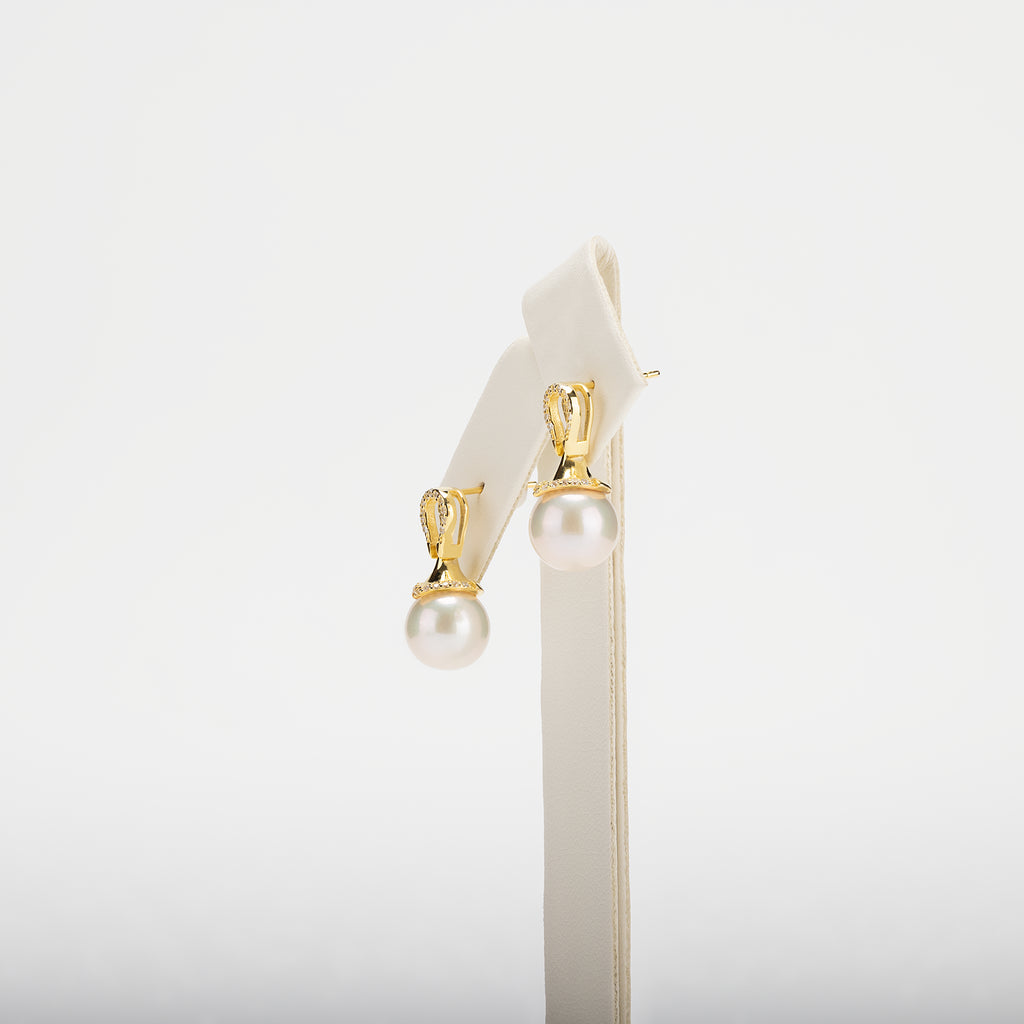Pearl earrings with gold clasps on a white background