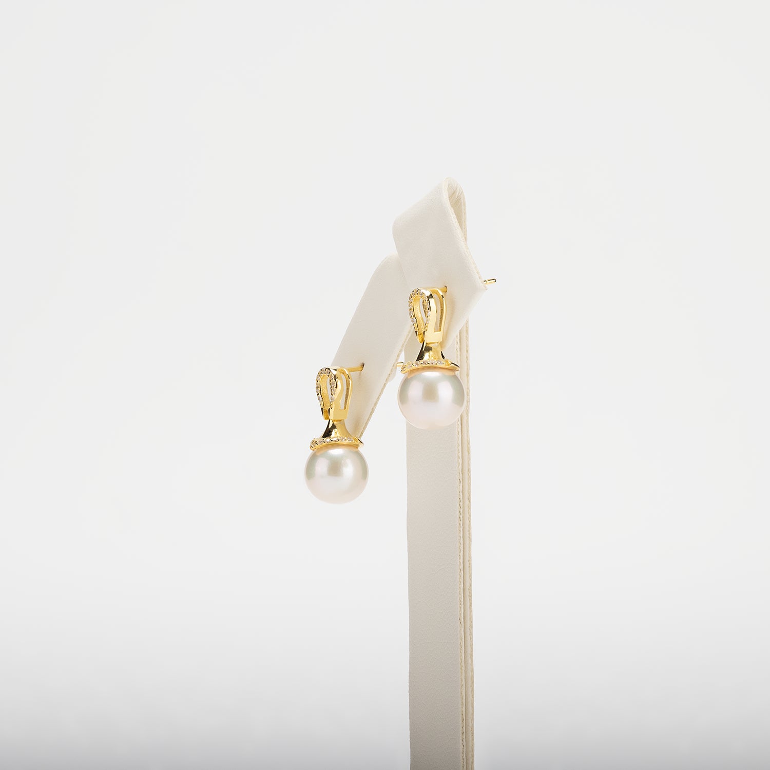 Pearl earrings with gold clasps on a white background