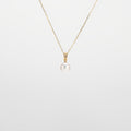 Pearl Drop Necklace with gold chain on a light gray background