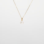 Pearl Drop Necklace with gold chain on a light gray background