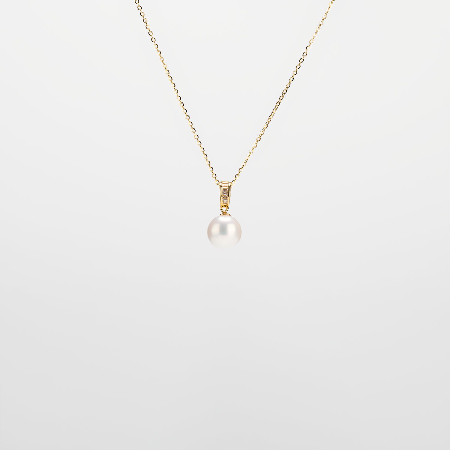 Pearl Drop Necklace with gold chain on a light gray background
