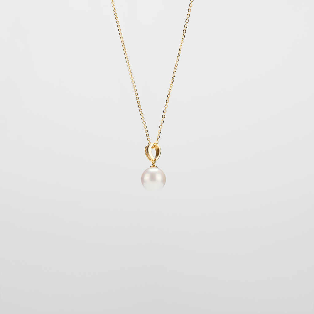 Pearl Drop Necklace with gold chain on a light gray background
