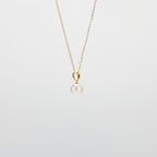 Pearl Drop Necklace with gold chain on a light gray background