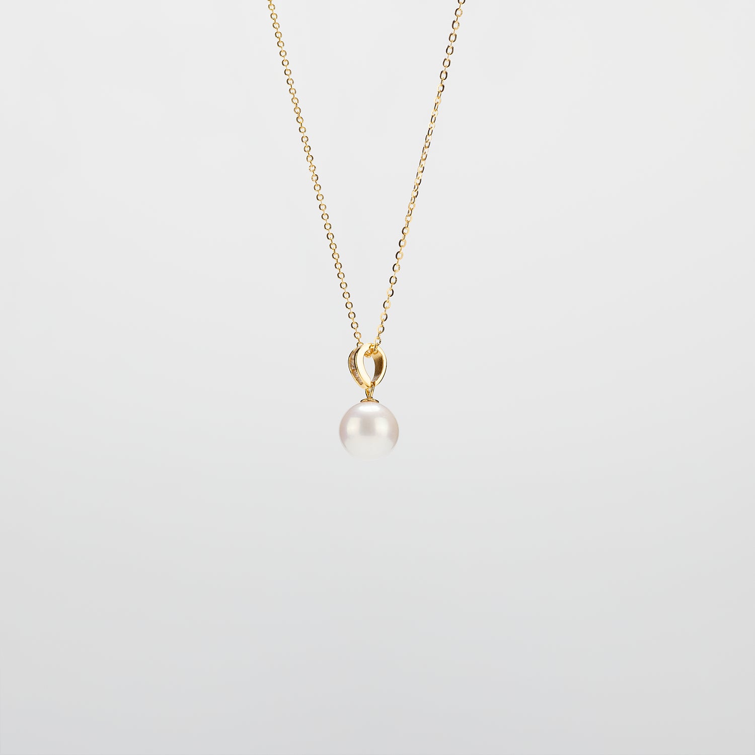 Pearl Drop Necklace with gold chain on a light gray background