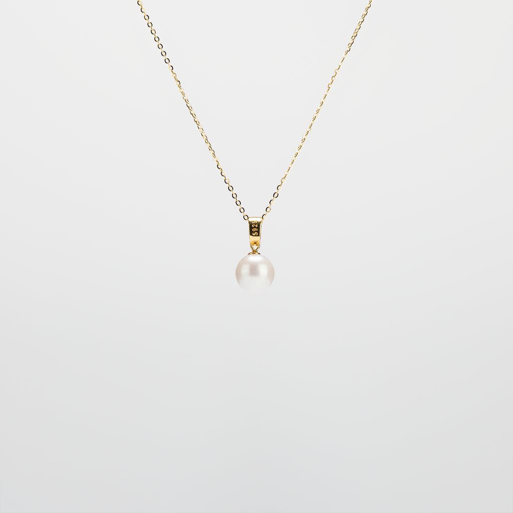 Pearl Drop Necklace with gold chain on a light gray background