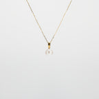 Pearl Drop Necklace with gold chain on a light gray background