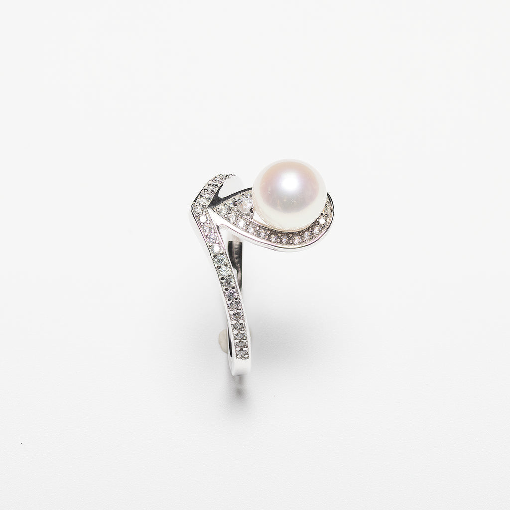 Pearl ring with diamond accents on a white background