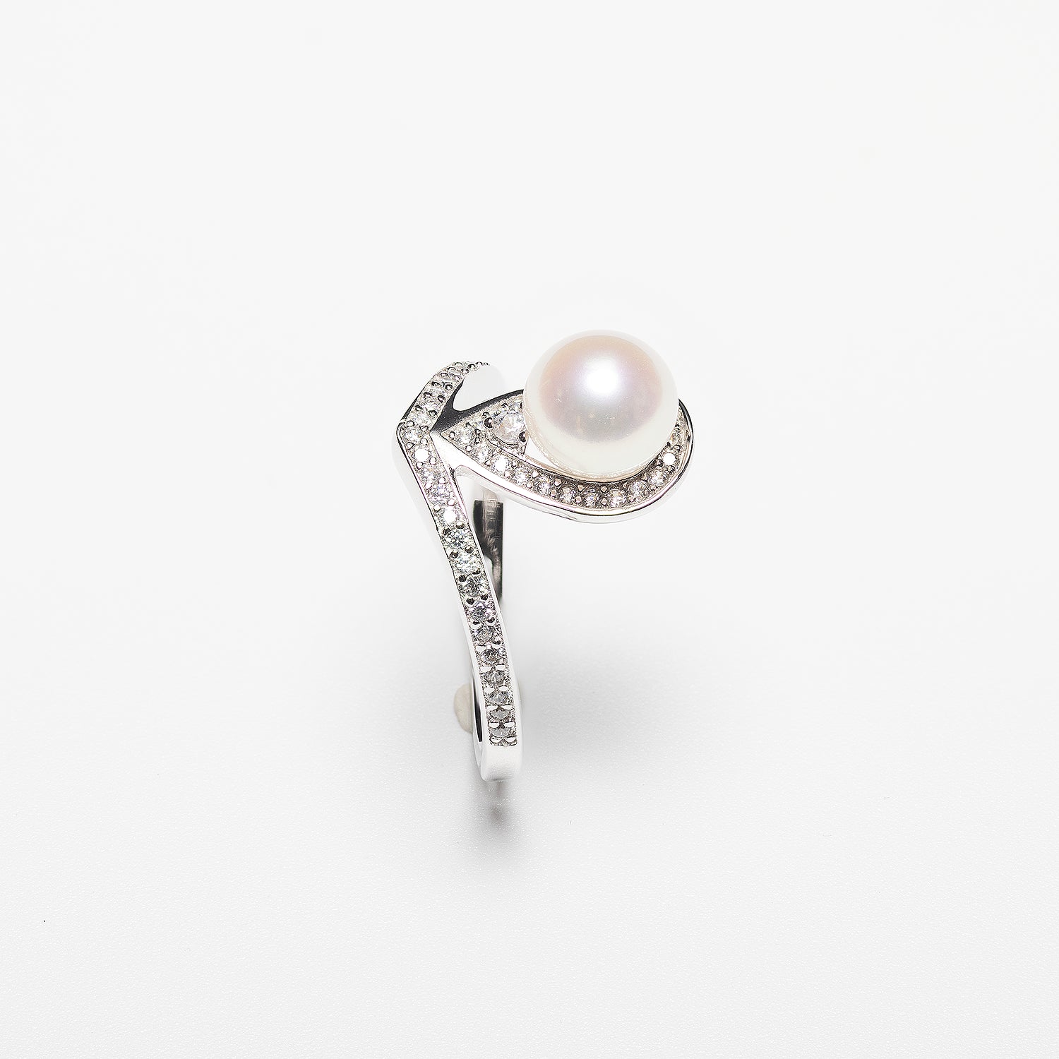 Pearl ring with diamond accents on a white background